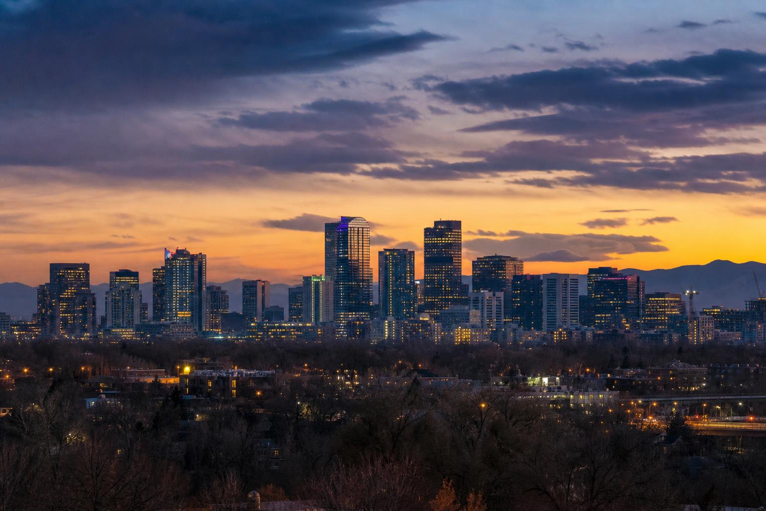Denver Colorado skyline at dusk with Rocky Mountains